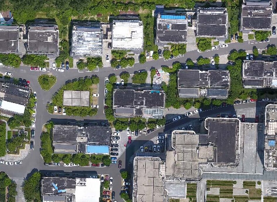 Bild von einer DJI M3E Drohne aufgenommen über einer Wohngegend fliegend.