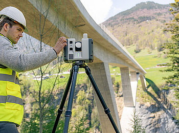 Leica RTC Gerät beim vermessen vor einer Brücke