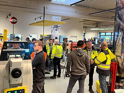 Raum mit Vermessungsgeräten und Interessenten zu Vermessungstechnik und Maschinensteuerung