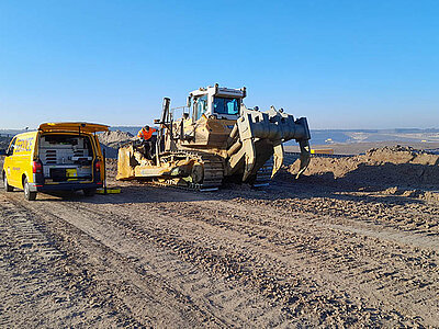 Service Fahrzeug von Beutlhauser und schweres Gerät auf Baustelle