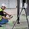 Arbeiter hockt am Boden und vermisst mit einem RTC360 die Umgebung