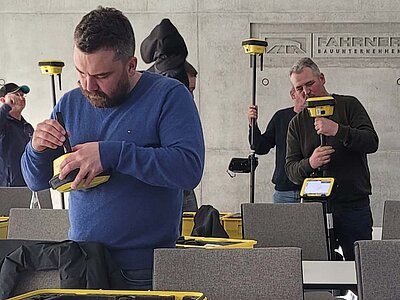 Schulungsteilnehmer beim zusammenbauen eines GNSS-Roverstabs