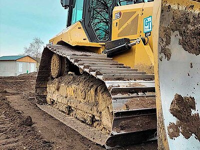 Raupe mit Schild seitliche Ansicht von Gertl Tiefbau - auf einer Baustelle