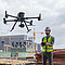 Drohne DJI Matrice 350 RTK wird von einem Arbeiter auf der Baustelle im Hochbau geflogen