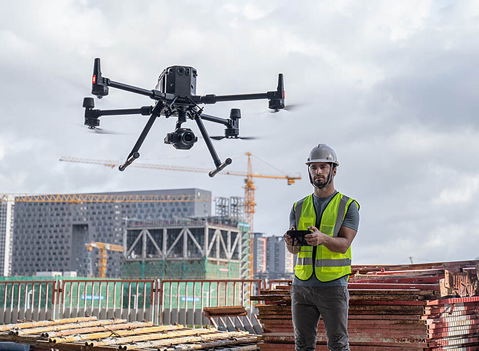 Drohne DJI Matrice 350 RTK wird von einem Arbeiter auf der Baustelle im Hochbau geflogen