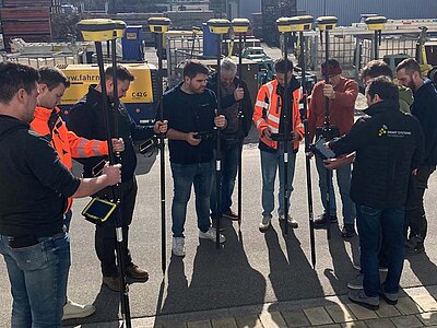 Schulungsteilnehmer testen in der Praxis am Gelände die Möglichkeiten eines GNSS-Roverstabs