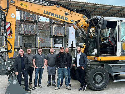 Teilnehmer an der G8 Liebherr Mobilbagger Schulung neben besagter Maschine