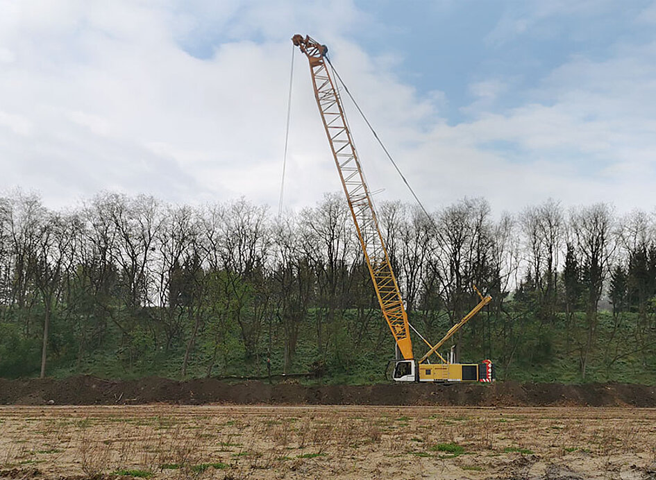 Baustelle aus der Ferne sieht man wie eine Fallgewichtsverdichtung gemacht wird.