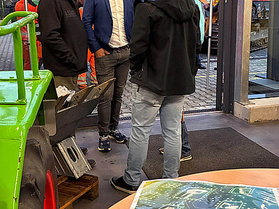 Gesprächsrunde beim Event "Präzision trifft BBQ" - im Vordergrund eine Smart Systems Broschüre