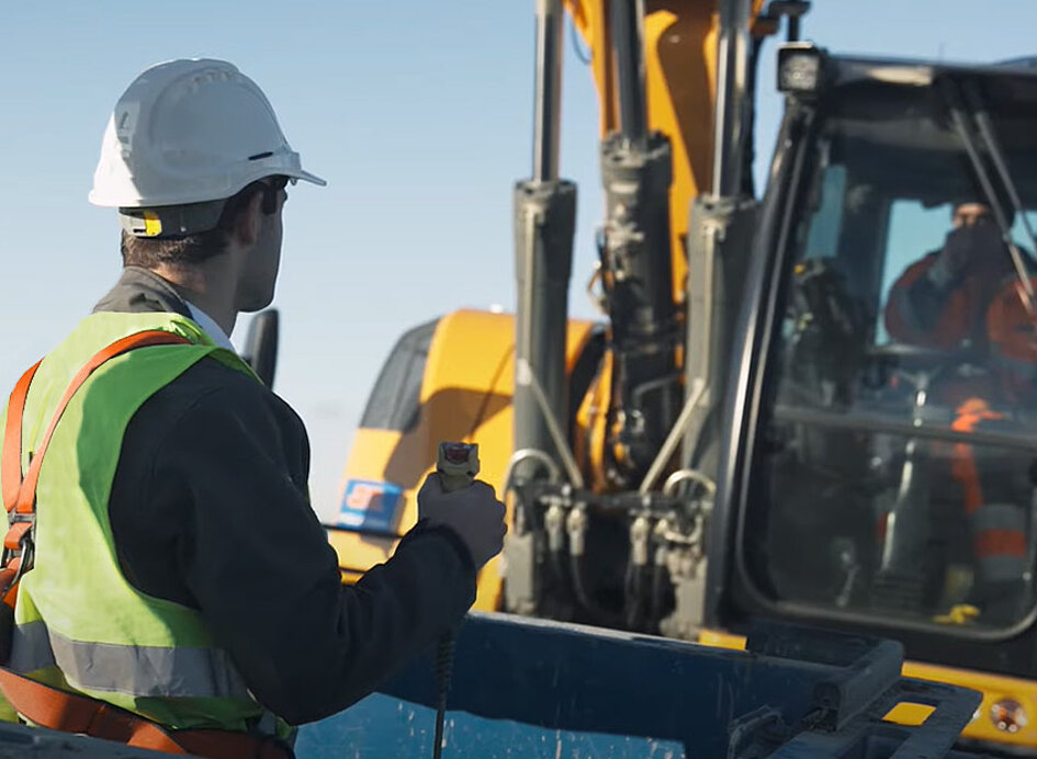 Baustelle mit Arbeitskorb, Arbeiter und Maschine