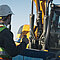 Baustelle mit Arbeitskorb, Arbeiter und Maschine
