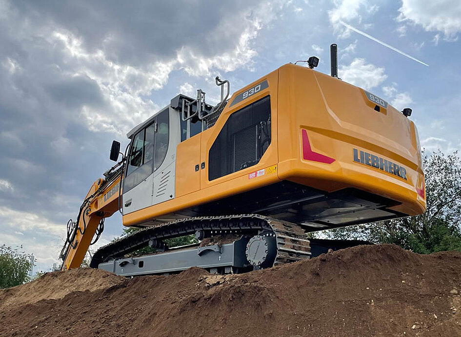 Kettenbagger von Liebherr mit Leica 2D- und 3D-Maschinensteuerung ausgestattet. Auf einem Erdhaufen stehend.