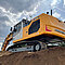 Kettenbagger von Liebherr mit Leica 2D- und 3D-Maschinensteuerung ausgestattet. Auf einem Erdhaufen stehend.