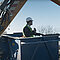 Bagger hält Arbeitskorb mit Arbeiter auf einer Baustelle in Position
