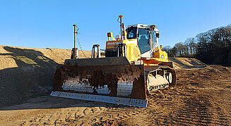 Raupe mit Maschinensteuerung ebnet eine Baustelle
