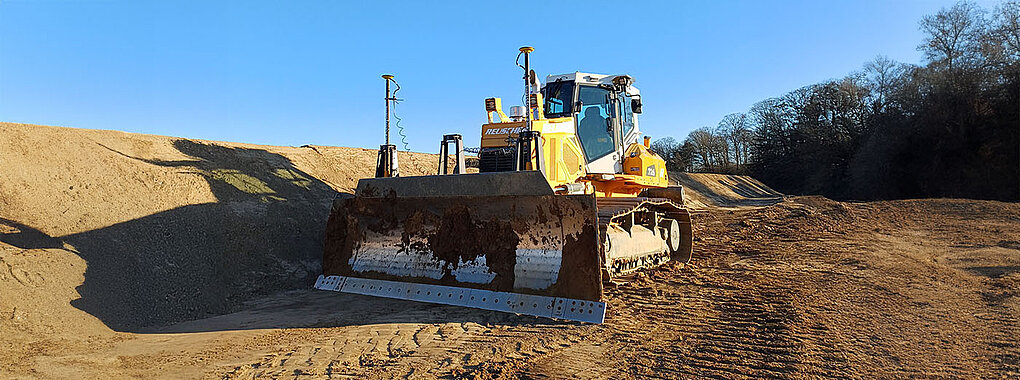 Raupe mit Maschinensteuerung ebnet eine Baustelle