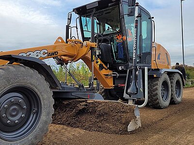 Grader mit 2D-Steuerung ebnet Erde auf einer Baustelle